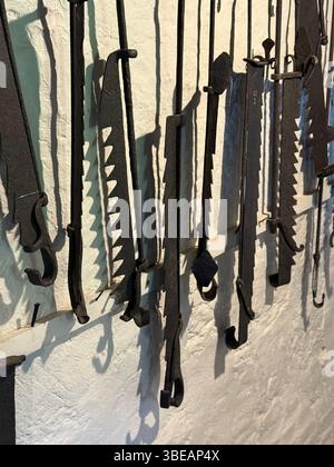 Old fashioned irons with teeth. Called andirons, adjustable, used to lift cooking grates above the heat to prevent burning the meat/food. Stock Photo