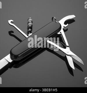 Multipurpose folding knife on a black background. Swiss army knife Stock Photo