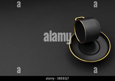 A set of black and golden ceramic plates and cup on a black background Stock Photo