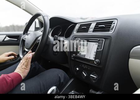 Man siting in the car and using autopilot and navigation app on the car screen. Futuristic self driven transport. Stock Photo