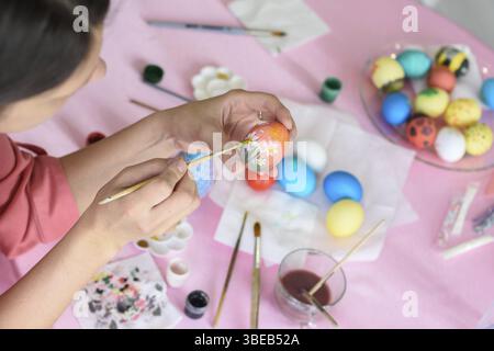 Girl paints chicken eggs for Easter Stock Photo