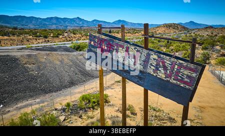 Aerial of Weathered Nothing Sign in Desert Landscape with Highway Stock Photo