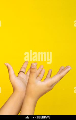A creative studio composition featuring a human hand extended on a single-tone background. Designed to be used in advertising campaigns where the hand Stock Photo