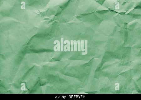 Recycled crumpled green colored paper texture. Wrinkled craft paper background, rough cardboard surface, wallpaper, backdrop. Design element, copy spa Stock Photo