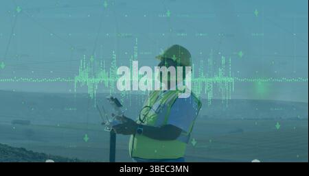 Engineer wearing hard hat and safety vest piloting drone with remote on rocky slope, with telemetry Stock Photo