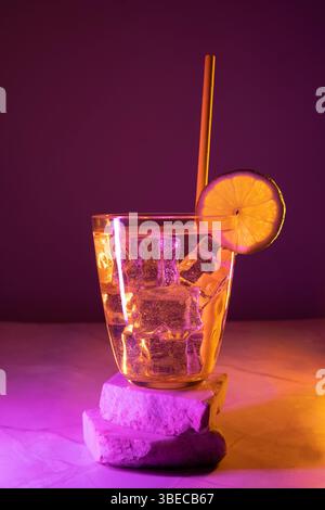 glass with cocktail and lemon and colored lights Stock Photo