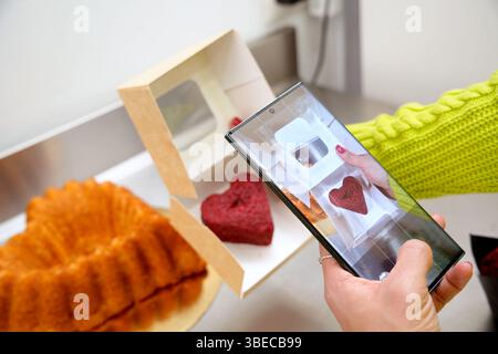 photographing heart-shaped biscuit in its box Stock Photo