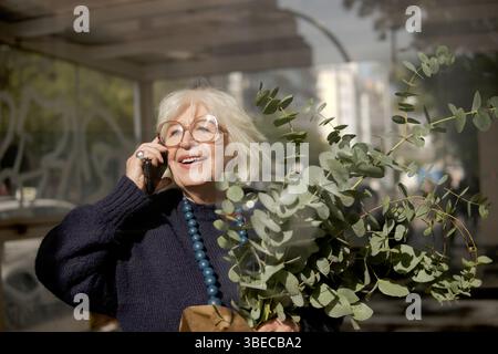 older woman talking on the phone outdoors Stock Photo