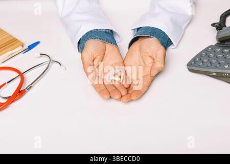 Close up of the hands of an Audiologist holding a hearing aid in the palm of his hands. Conceptop audiology. Stock Photo