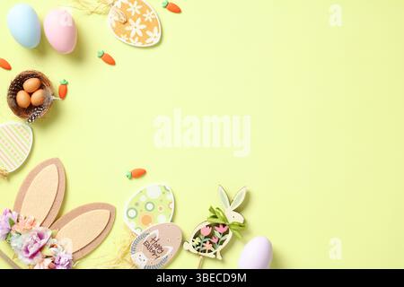 Happy Easter flat lay composition. Top view rabbit bunny ears, Easter eggs, wooden decorations on pastel green background. Stock Photo