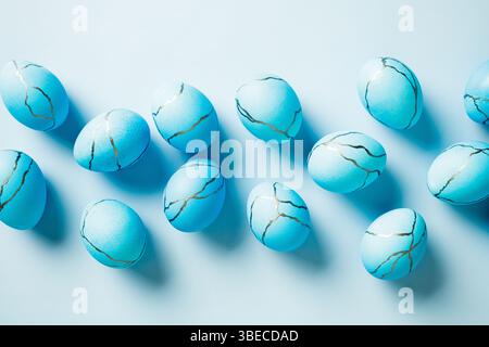 Blue Easter eggs painted marble texture on light blue background. Flat lay, top view. Stock Photo