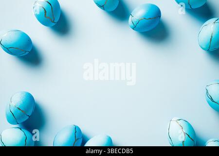 Elegant Easter background with blue Easter eggs on pastel blue table. Minimal style. Stock Photo