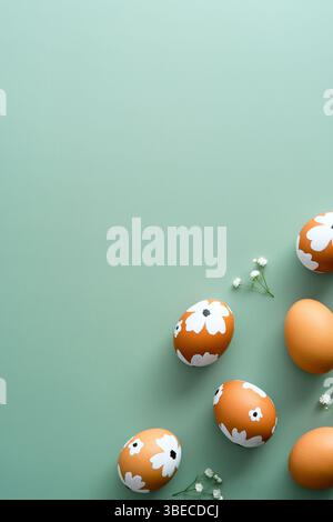 Elegant Easter flat lay composition. Easter painted eggs and flowers on pastel green background. Flat lay, top view. Happy Easter vertical banner temp Stock Photo