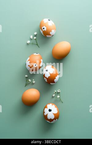 Colorful painted Easter eggs on green background with gypsophila. Elegant Easter flat lay composition Stock Photo