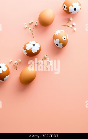 Easter eggs with gypsophila flowers on color background. Flat lay, top view, vertical. Stock Photo
