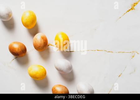 Elegant Easter flatlay composition. Luxury bronze Easter eggs on marble table. Flat lay, top view. Stock Photo