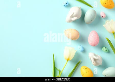Tulips, Easter eggs, bunnies on pastel blue background. Happy Easter greeting card design. Stock Photo