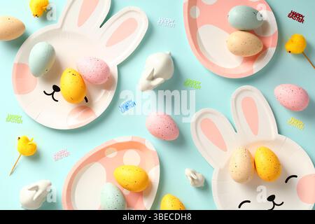Happy Easter concept. Easter table with plates, colorful eggs and decorations on blue background. Stock Photo