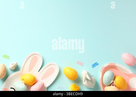 Easter card template. Frame border made of Easter cutlery and colorful Easter eggs. Flat lay, top view. Stock Photo