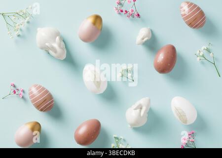 Stylish Easter eggs and decorative bunnies on pastel blue background. Happy Easter concept. Stock Photo