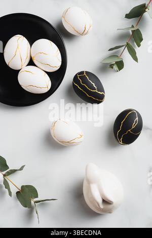 Luxury Easter flat lay composition with Easter eggs, eucalyptus leaves, bunny rabbit marble table. Happy Easter concept. Top view. Stock Photo
