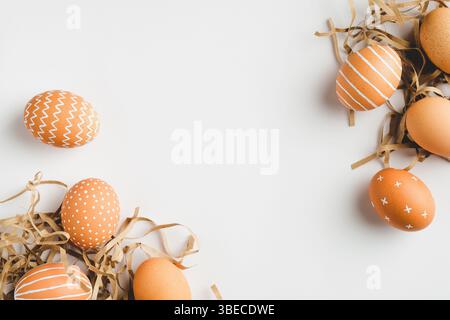 Happy Easter concept. Frame of elegant Easter eggs on white background. Flat lay, top view, copy space. Stock Photo