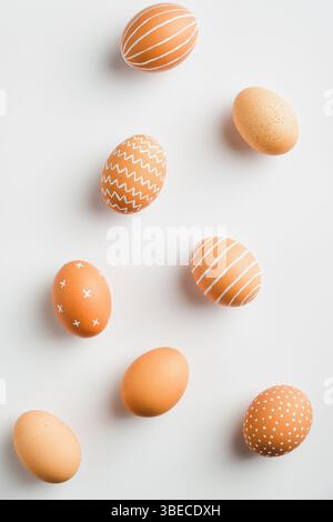 Happy Easter minimal flat lay style composition. Simple Striped and dotted Easter eggs on white background. Stock Photo