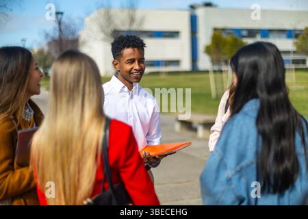 Group of cheerful multi ethnic university students chatting together on campus during a break between classes Stock Photo