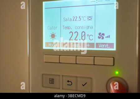 AIR CONDITIONING WALL CONTROLLER  and finger pushing button to turn on Stock Photo
