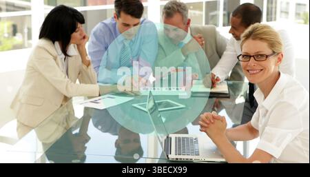 Image of globe over happy diverse businesspeople working together in office Stock Photo