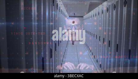 Image of caucasian male hacker over man walking in server room Stock Photo