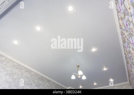 An outline of a stretch ceiling in a room with a chandelier and spotlights Stock Photo