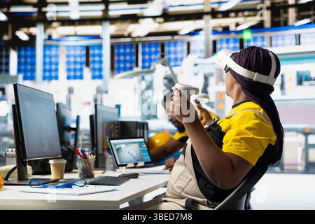 Solar panel plant technician using VR goggles to build generators for renewable energy, metaverse. Industrial factory engineer creates solar power using virtual reality gear, production. Stock Photo