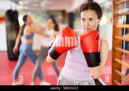 Adult woman practices punch with boxing gloves Stock Photo