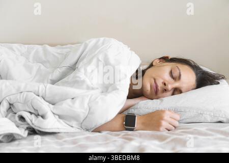 Young woman goes to sleep Phone addiction, insomnia. try to fall asleep ...