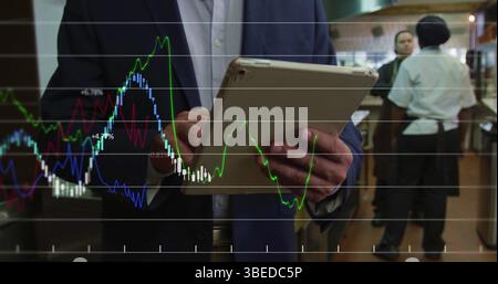 Financial data processing against mid section of manager using digital tablet in restaurant kitchen Stock Photo