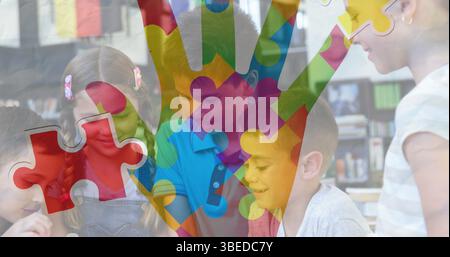 Jigsaw puzzle and hand icon against diverse group of students using digital tablet at school Stock Photo