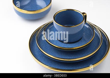 A set of blue ceramic plates and cup on a white background Stock Photo