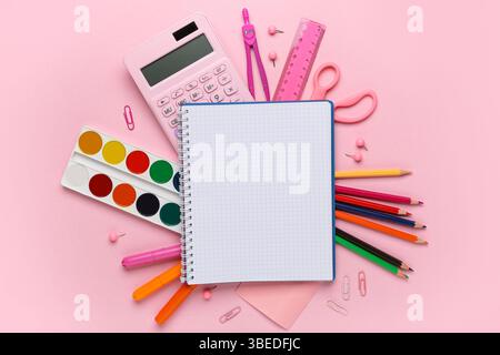 Composition with opened blank notebook and school stationery on pink background Stock Photo