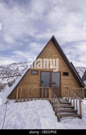 A vertical shot of a wooden cottage surrounded by snow. A recreation area in the mountains Stock Photo