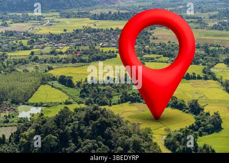 Aerial view of a red GPS location pin marking a spot on lush farmland and village, symbolizing navigation, location tracking, and digital map technolo Stock Photo