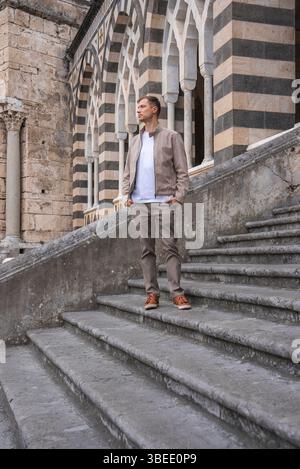 Man Standing on Stone Steps in Front of Amalfi Cathedral, Italy Stock Photo