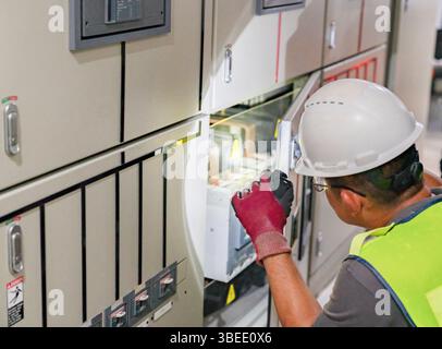 The electrician engineer open flashlight to inspection the hot spot of a power inverter and generator controller. Stock Photo