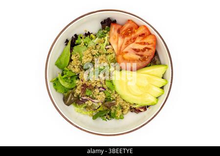 Top view of quinoa salad with fresh greens tomato slices and avocado slices arranged in a ceramic bowl on white background Stock Photo