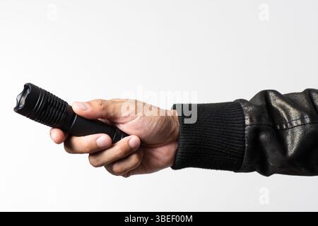 The man holding a LED flashlight in hand. Stock Photo