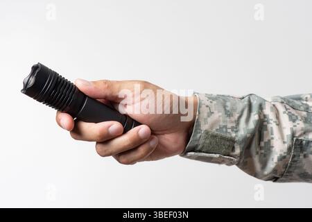 The man holding a LED flashlight in hand. Stock Photo