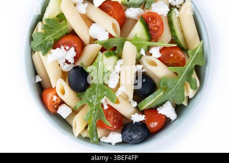 Mediterranean Pasta Salad in bowl with Fresh Vegetables and Herbs isolated on white background. Stock Photo