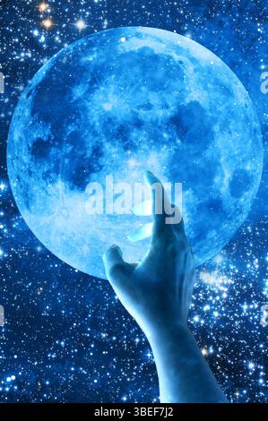 woman hand touching a blue moon Stock Photo