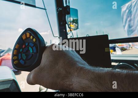 Close Up View of the Hand Driving on a Tractor Inside the Cabin in Daytime. Stock Photo