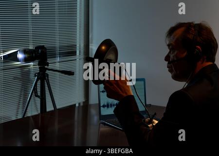 The detective conducts covert surveillance using modern gadgets and sound recordings Stock Photo